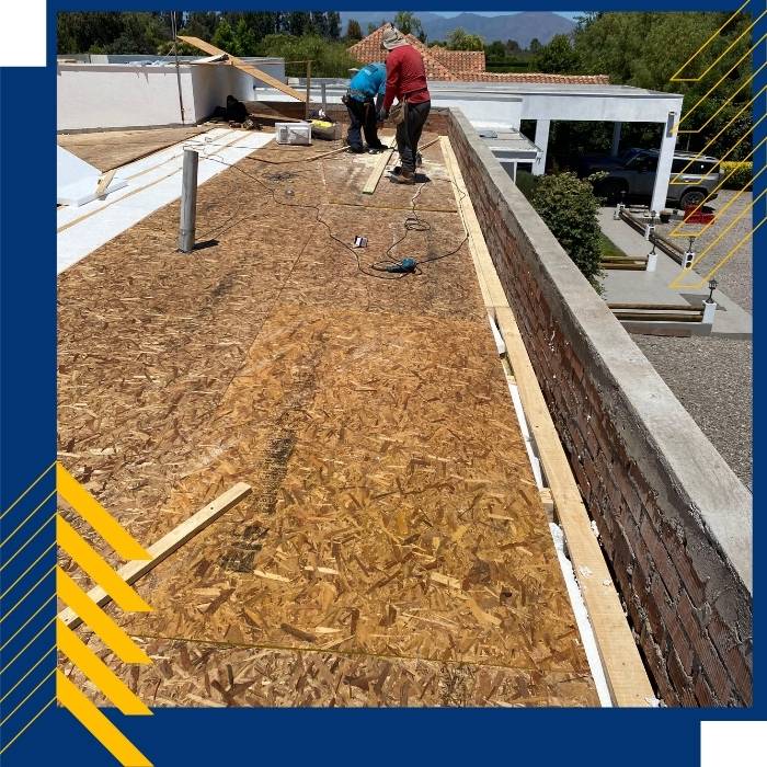 Equipo de HojatevalSpa instalando cubierta metálica en proyecto industrial en altura.